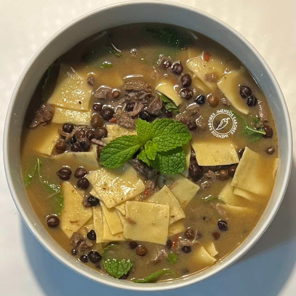 Sopa de grão-de-bico preto com carne, massa caseira e hortelã